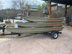 The Image of 2025 Tracker Grizzly 1036 Utility boats stacked on a trailer outdoors. - 0