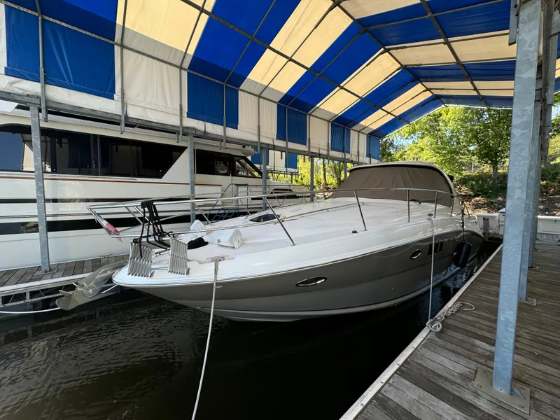 The Image of 2006 Sea Ray 38 Sundancer yacht docked under a blue and white canopy. - 0