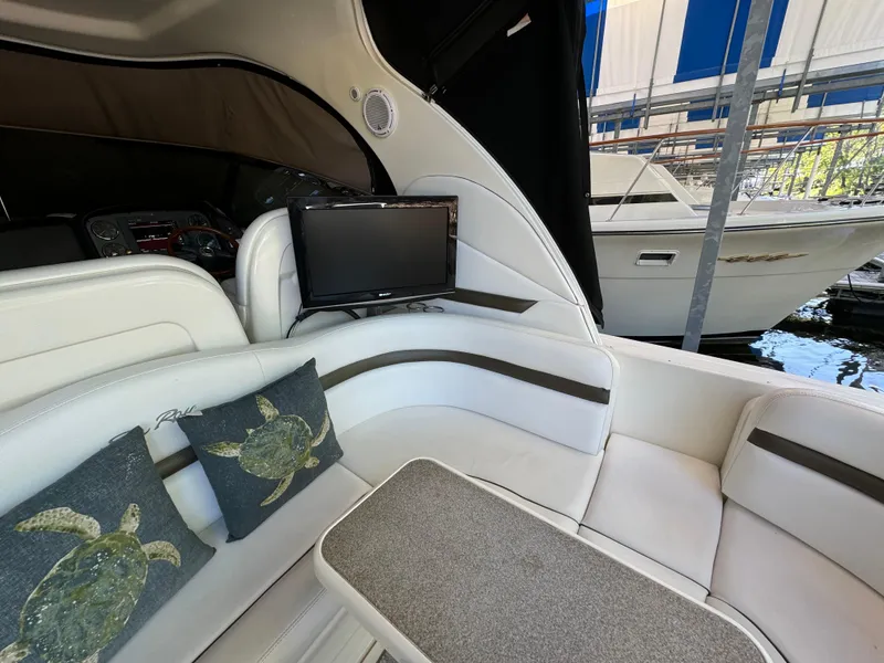 Slide: The Image of Interior of 2006 Sea Ray 38 Sundancer with seating, TV, and turtle-themed pillows. - 12