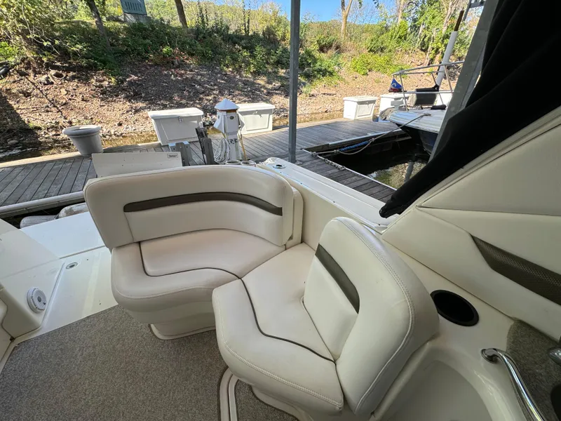 Slide: The Image of 2006 Sea Ray 38 Sundancer boat interior with white seating and dock view. - 13