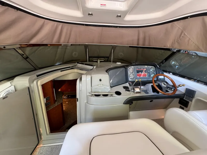 Slide: The Image of 2006 Sea Ray 38 Sundancer helm with wood-accented steering wheel and cabin entrance. - 17