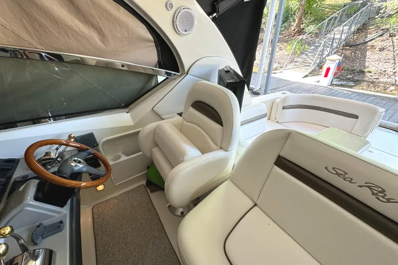 Slide: The Image of 2006 Sea Ray 38 Sundancer cockpit with leather seating and wooden steering wheel. - 18