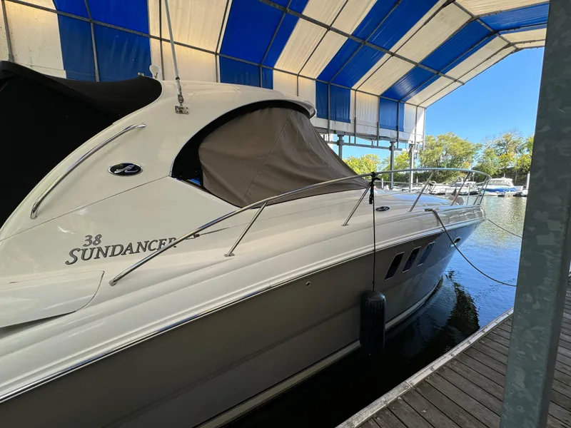 Slide: The Image of 2006 Sea Ray 38 Sundancer yacht docked under a blue and white canopy. - 2