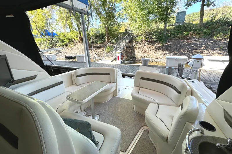 Slide: The Image of 2006 Sea Ray 38 Sundancer yacht interior with plush seating and table, docked near trees. - 21