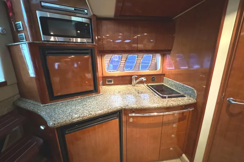 Slide: The Image of 2006 Sea Ray 38 Sundancer yacht kitchen with wood cabinets and granite countertops. - 25