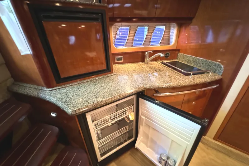 Slide: The Image of 2006 Sea Ray 38 Sundancer yacht kitchen with granite countertop and open fridge. - 27