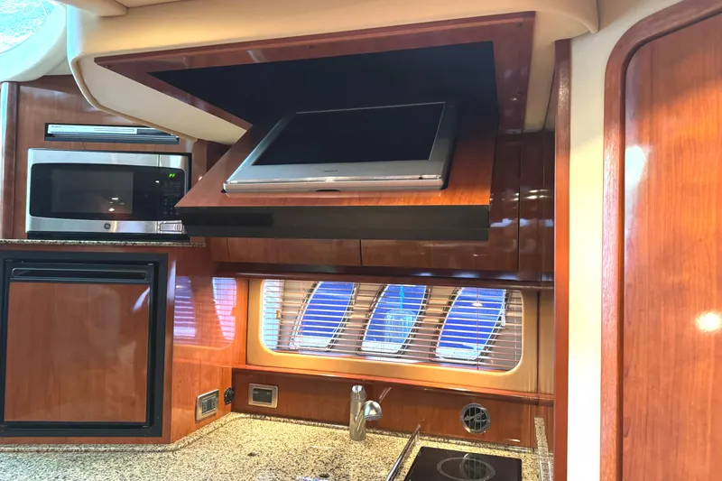 Slide: The Image of Interior of 2006 Sea Ray 38 Sundancer yacht with TV, microwave, and kitchen amenities. - 29