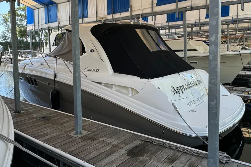 Slide: The Image of 2006 Sea Ray 38 Sundancer docked in a marina under a covered slip. - 3