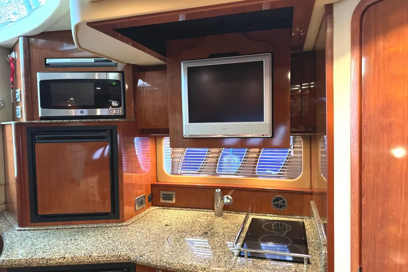 Slide: The Image of Interior of 2006 Sea Ray 38 Sundancer yacht with kitchen appliances and TV. - 30