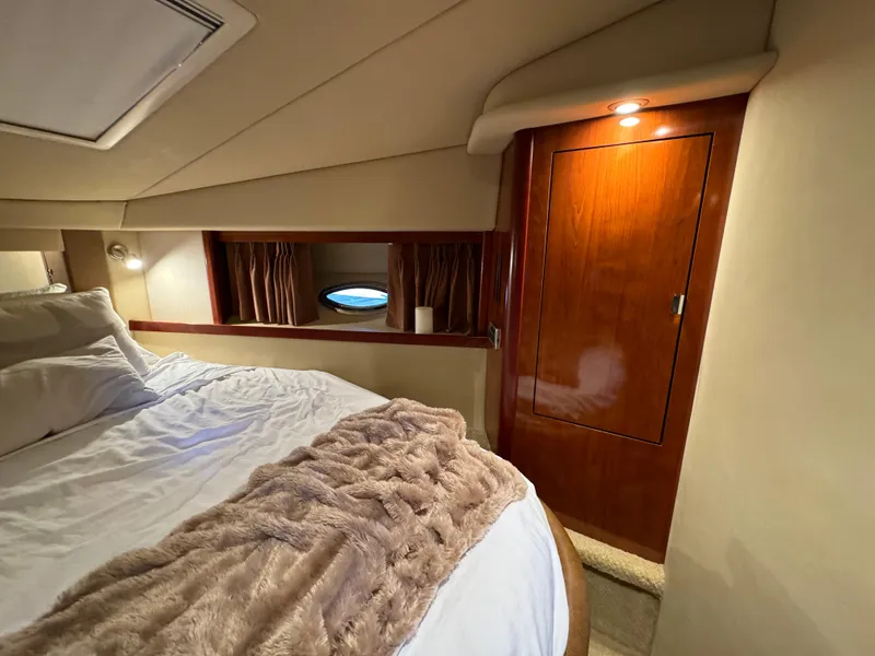 Slide: The Image of Luxurious cabin interior of 2006 Sea Ray 38 Sundancer with cozy bedding and wooden cabinetry. - 38