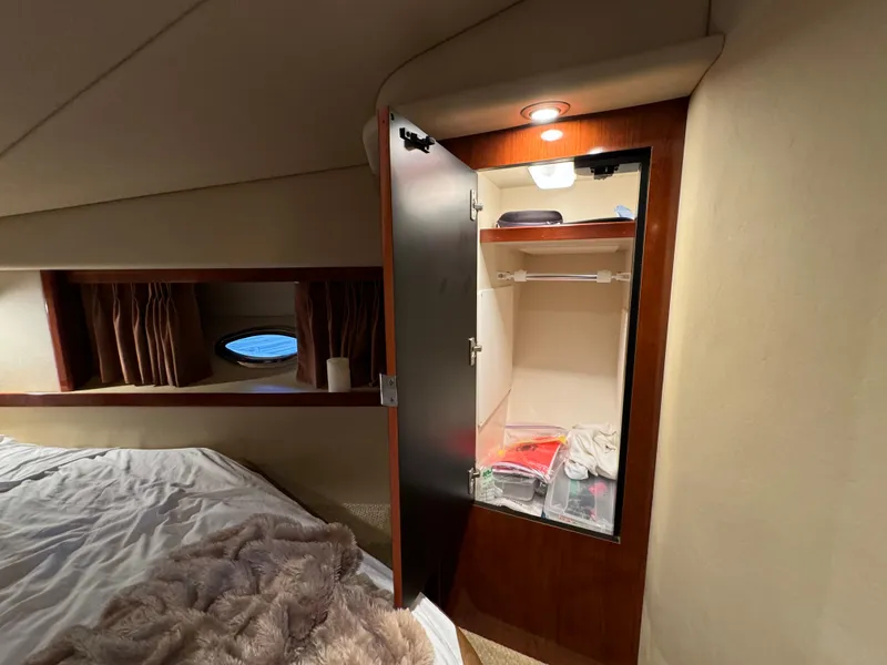 Slide: The Image of Interior cabin of 2006 Sea Ray 38 Sundancer with open closet and bed. - 39