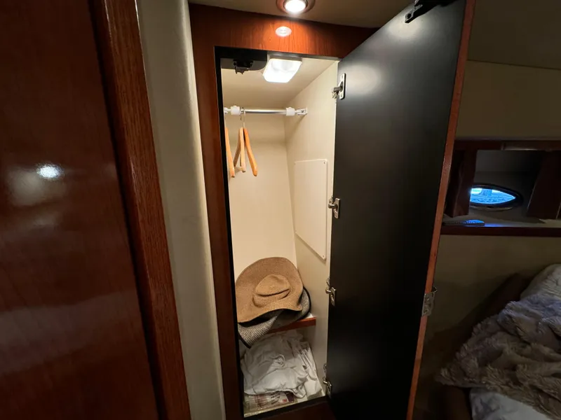 Slide: The Image of 2006 Sea Ray 38 Sundancer cabin closet with hangers and a hat. - 41