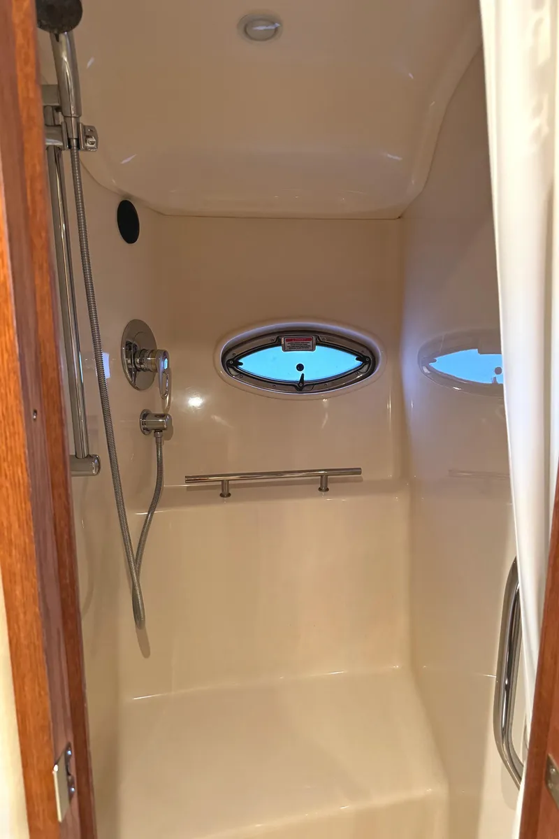 Slide: The Image of 2006 Sea Ray 38 Sundancer shower with oval window and chrome fixtures. - 45