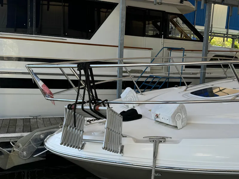 Slide: The Image of 2006 Sea Ray 38 Sundancer yacht docked, showcasing sleek bow design and stainless steel railings. - 7