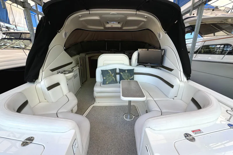 Slide: The Image of 2006 Sea Ray 38 Sundancer yacht interior with white seating and small table. - 9
