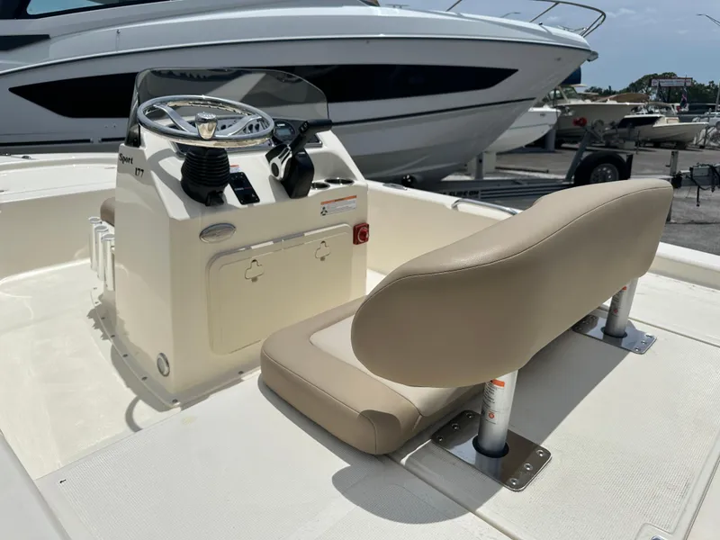 Slide: The Image of 2025 Scout 177 Sport boat interior with steering console and beige seating. - 3