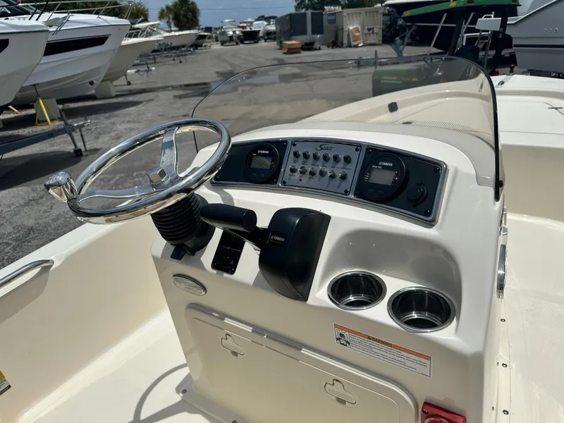 Slide: The Image of 2025 Scout 177 Sport boat dashboard with steering wheel and controls. - 6