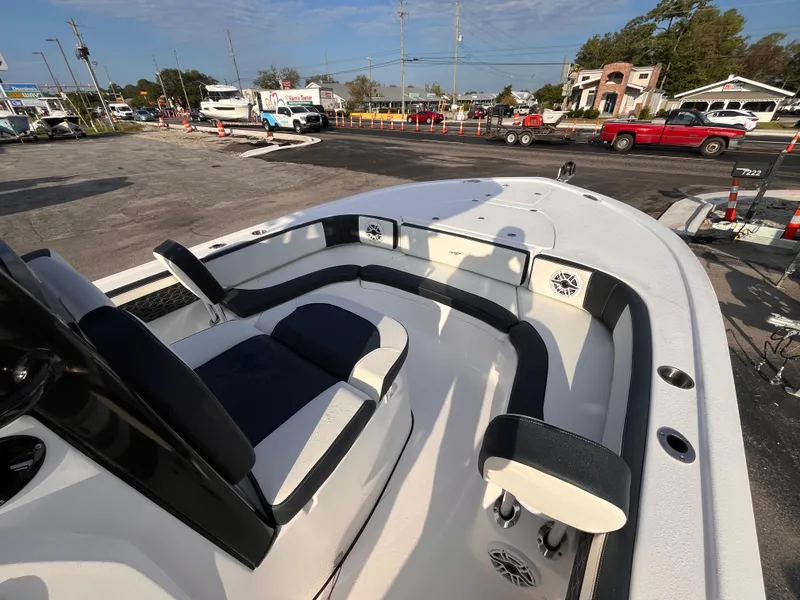 Slide: The Image of 2025 Tidewater 2700 Carolina Bay boat interior with seating and speakers, parked outdoors. - 11