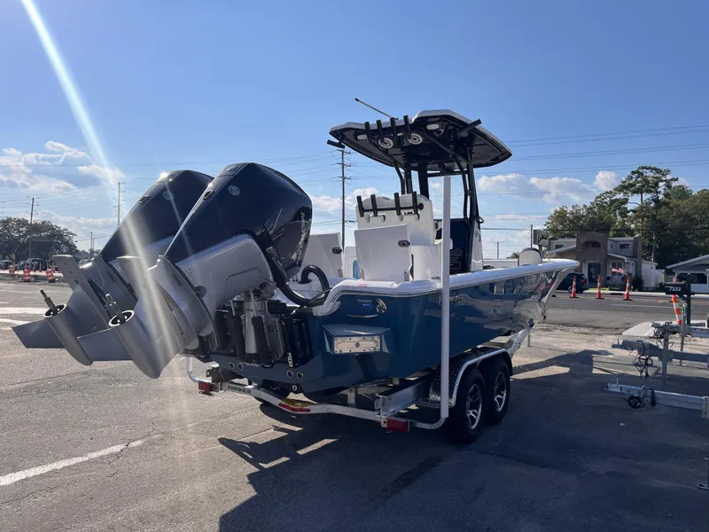 Slide: The Image of 2025 Tidewater 2700 Carolina Bay boat with dual engines on a trailer in a parking lot. - 3