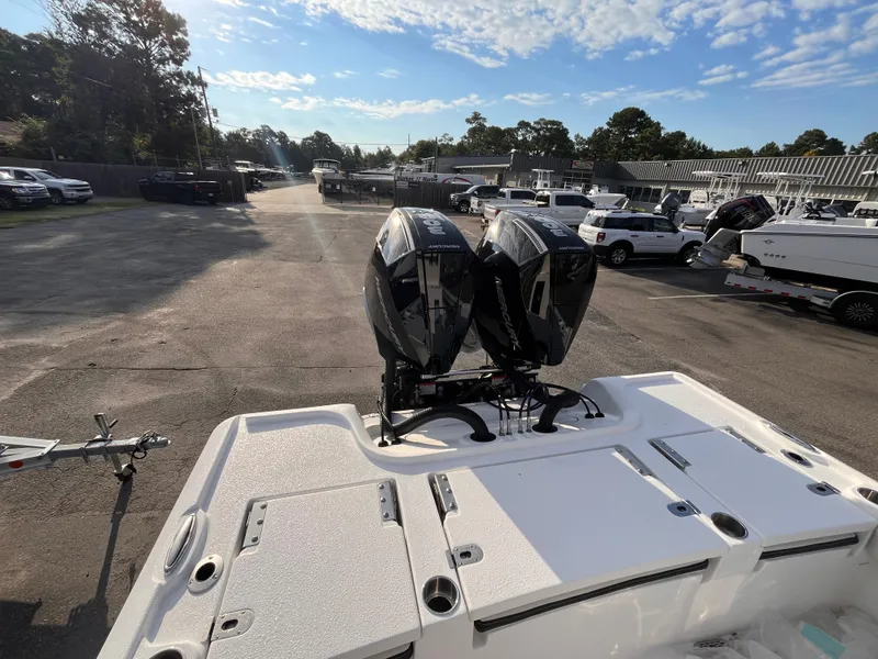 Slide: The Image of 2025 Tidewater 2700 Carolina Bay boat with dual outboard motors in a parking lot. - 4