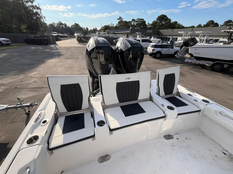 Slide: The Image of 2025 Tidewater 2700 Carolina Bay boat with seating and dual engines in a parking lot. - 5