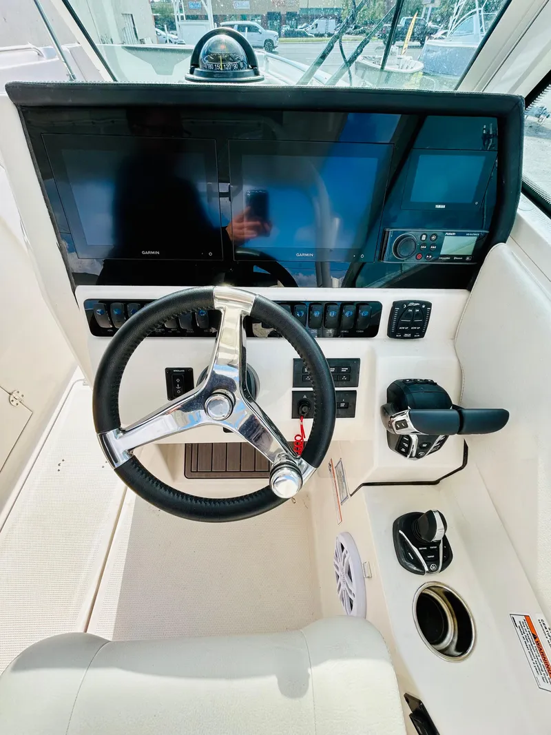Slide: The Image of 2024 Sailfish 276 DC boat cockpit with steering wheel and modern navigation controls. - 11