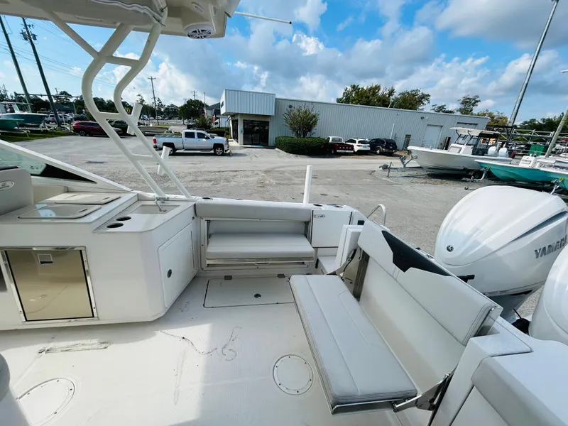 Slide: The Image of 2024 Sailfish 276 DC boat interior with seating and Yamaha engines in a marina setting. - 13