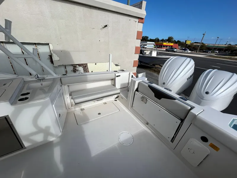 Slide: The Image of 2024 Sailfish 276 DC boat deck with dual outboard motors, urban background. - 16