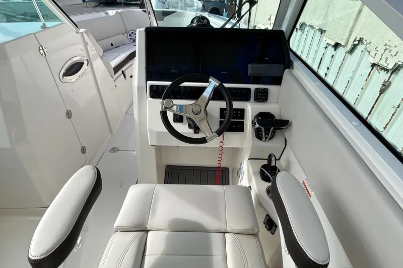 Slide: The Image of 2024 Sailfish 276 DC boat cockpit with modern steering and controls. - 25