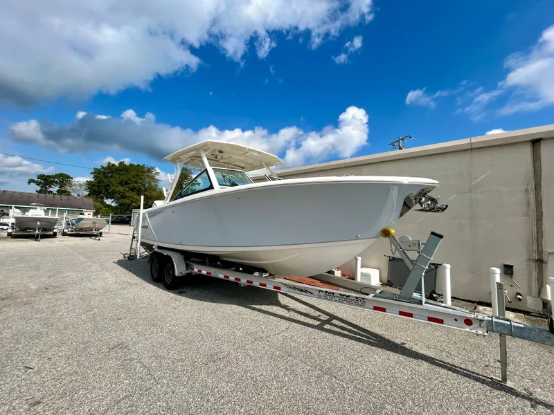 Slide: The Image of 2024 Sailfish 276 DC boat on trailer under blue sky. - 3