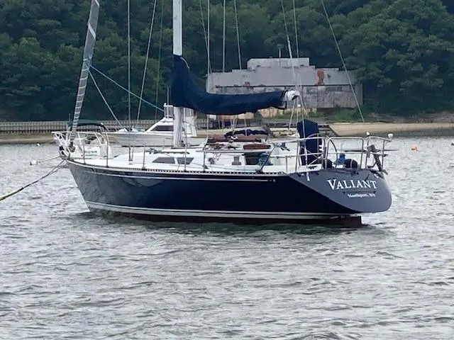 The Image of 1988 C&C 41 sailboat "Valliant" anchored on calm water near a wooded shoreline. - 1