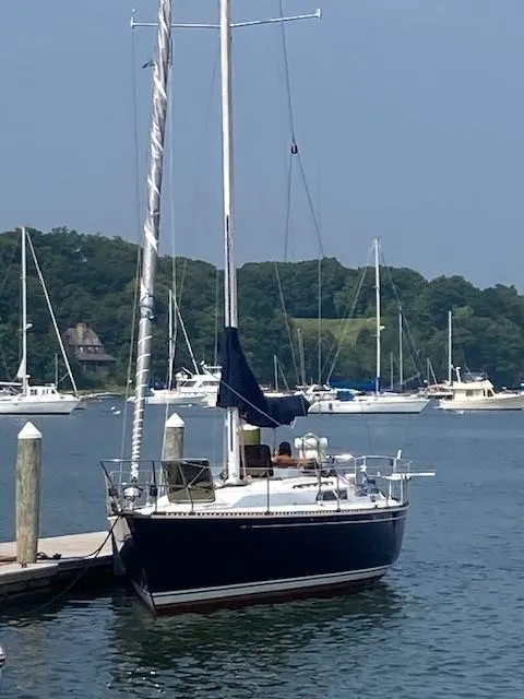 Slide: The Image of 1988 C&C 41 sailboat docked in a serene marina setting. - 10