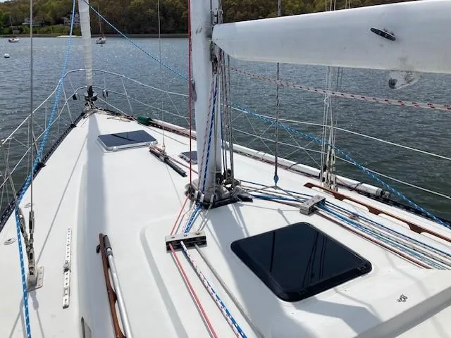 Slide: The Image of Sailboat deck of 1988 C&C 41 with rigging and hatches on calm water. - 16