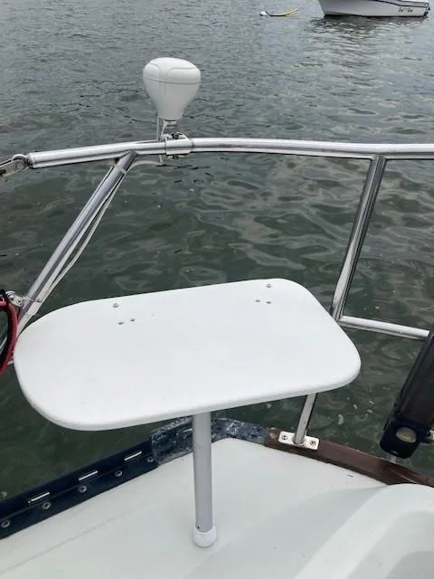 Slide: The Image of 1988 C&C 41 sailboat deck with white table and railing, on calm water. - 43