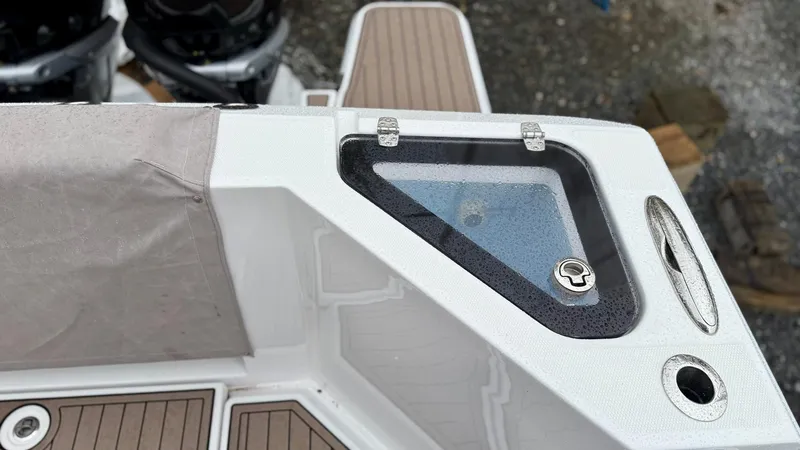 Slide: The Image of 2022 Bertram 28 CC boat detail with storage compartment and teak flooring. - 17