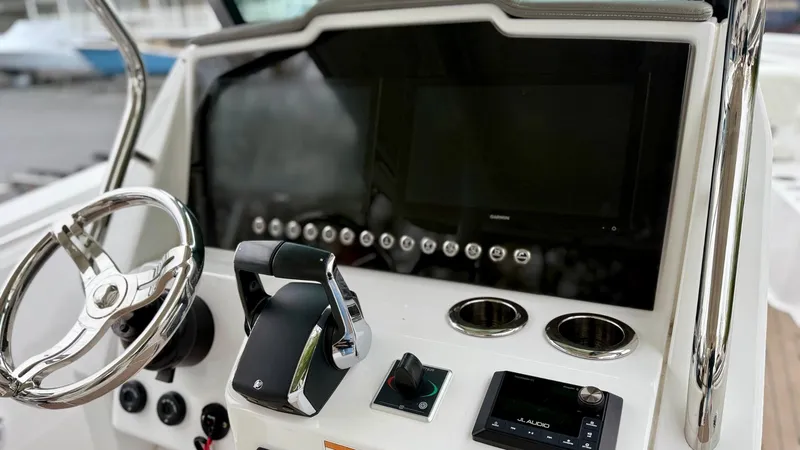 Slide: The Image of 2022 Bertram 28 CC boat dashboard with steering wheel and control panel. - 2