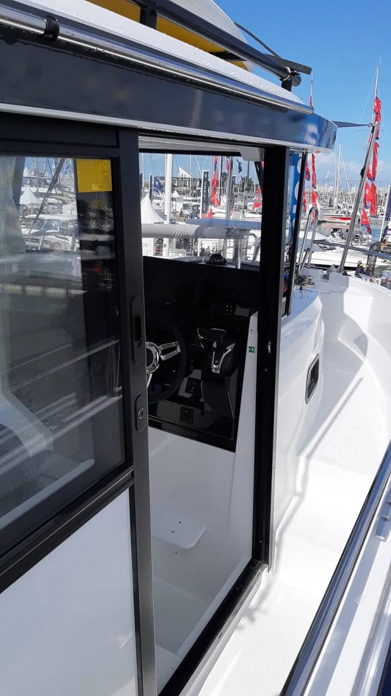 Slide: The Image of 2025 Jeanneau 795 SPORT S2 boat, side view with open cabin door at marina. - 12