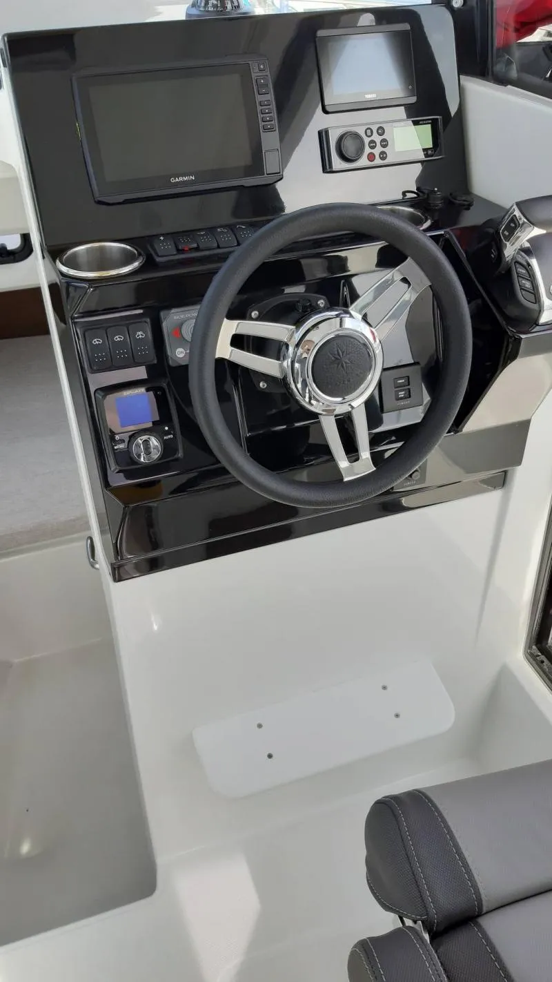 Slide: The Image of 2025 Jeanneau 795 SPORT S2 boat dashboard with steering wheel and navigation controls. - 23