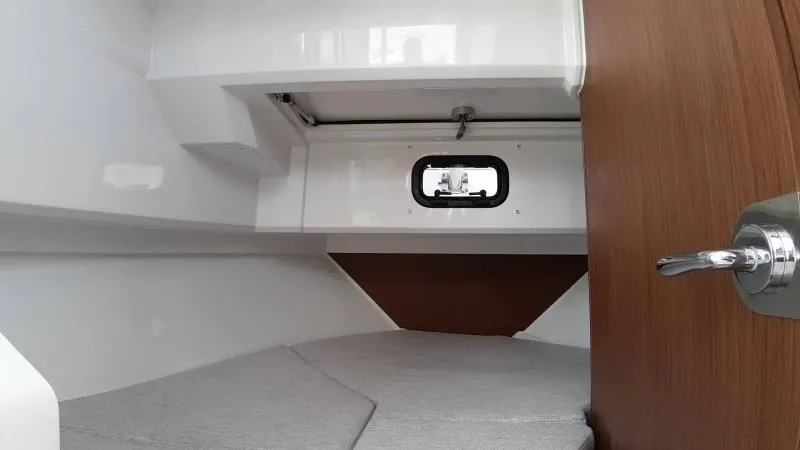 Slide: The Image of 2025 Jeanneau 795 SPORT S2 cabin interior with window and wooden accents. - 24