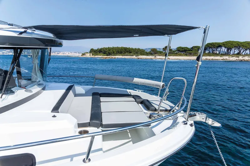 Slide: The Image of 2025 Jeanneau 795 SPORT S2 boat on calm blue water, featuring sleek design and sunshade. - 3