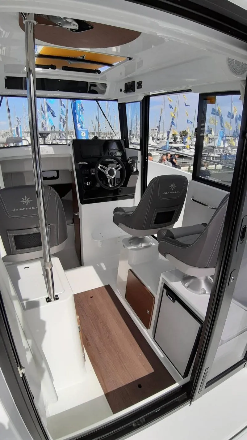 Slide: The Image of Interior of 2025 Jeanneau 795 SPORT S2 boat with modern seating and steering console. - 17