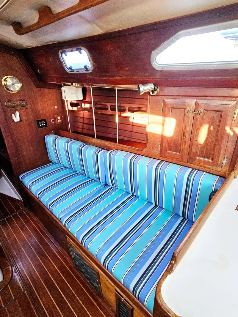 Slide: The Image of 1989 Ericson 35 MKIII interior with striped blue cushions and wooden cabinetry. - 38
