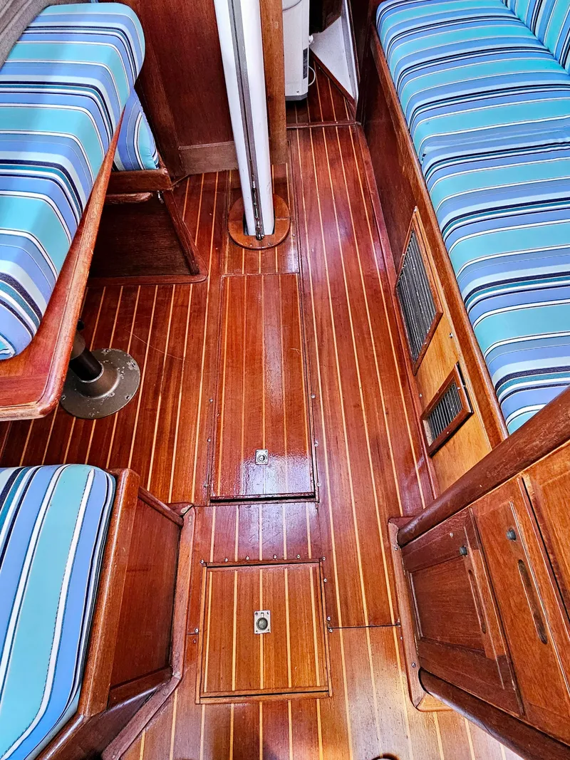 Slide: The Image of Interior of 1989 Ericson 35 MKIII sailboat with striped cushions and polished wooden flooring. - 39