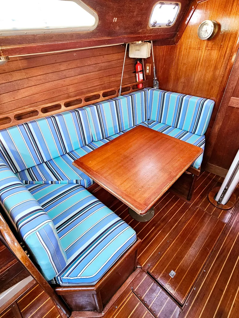 Slide: The Image of Cozy interior of 1989 Ericson 35 MKIII sailboat with striped cushions and wooden table. - 40
