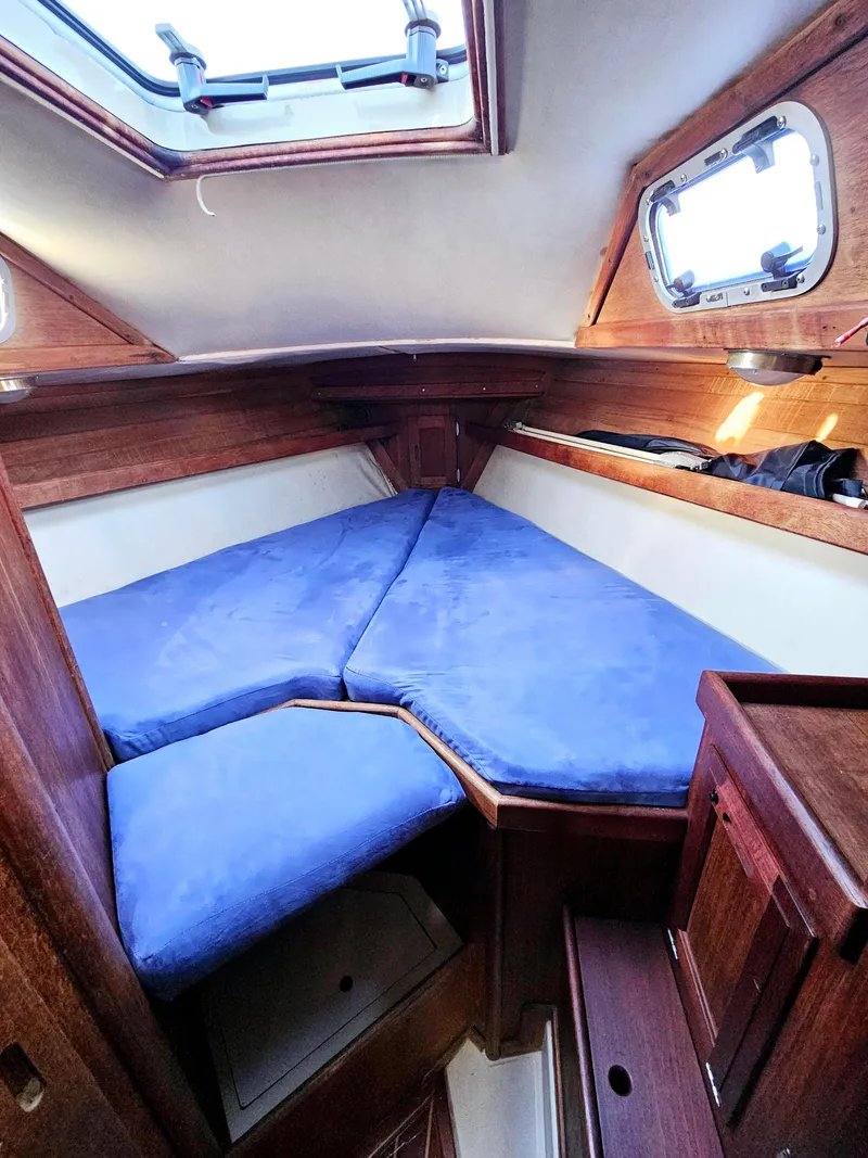 Slide: The Image of 1989 Ericson 35 MKIII sailboat interior with blue cushions and wooden finish. - 42