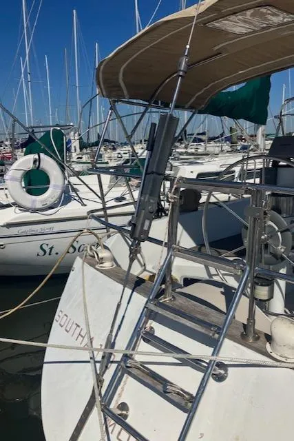 Slide: The Image of 1989 Ericson 35 MKIII sailboat docked in marina, featuring ladder and canopy. - 8