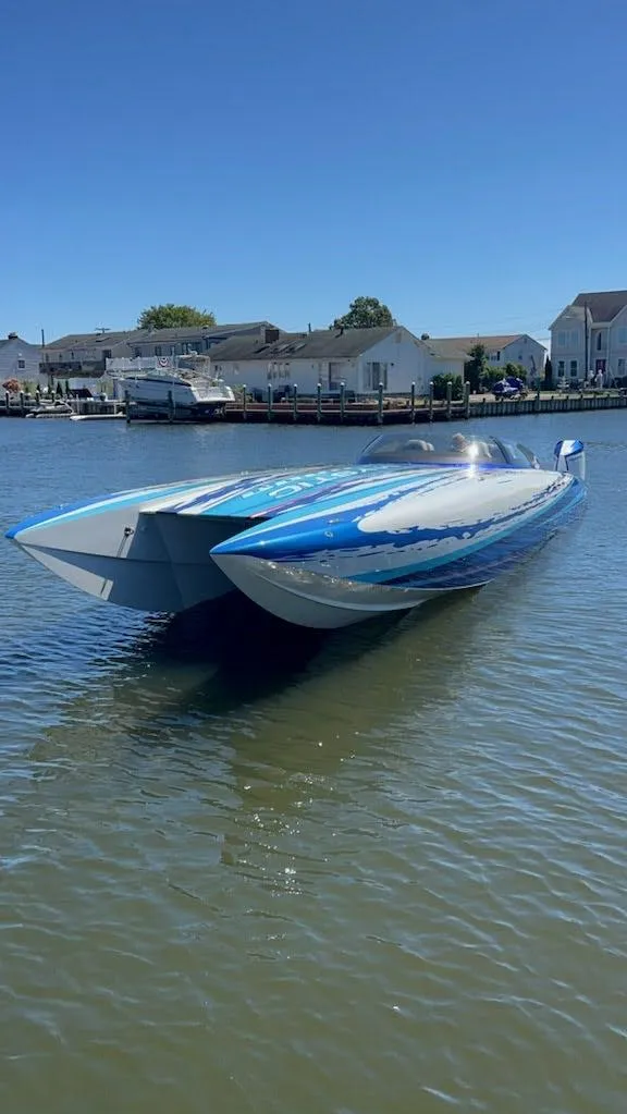 Slide: The Image of 2022 Mystic Powerboats C4000 on calm water, showcasing sleek design and vibrant blue accents. - 10