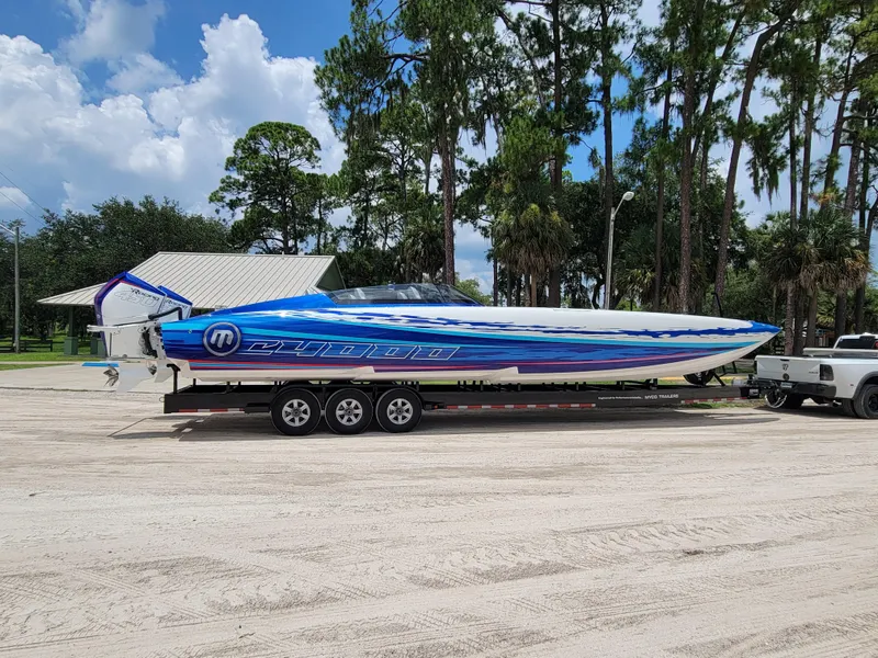Slide: The Image of 2022 Mystic Powerboats C4000 on trailer, vibrant blue design, parked outdoors. - 14