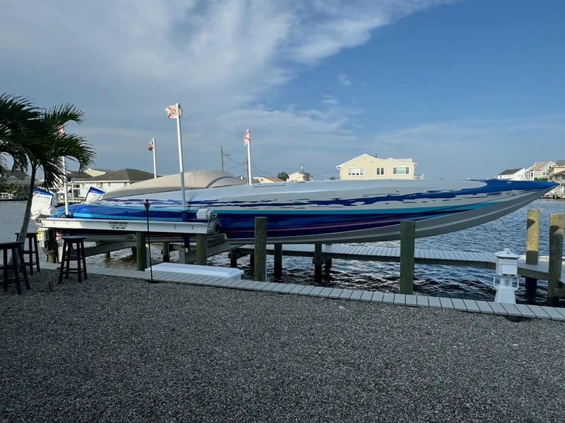 Slide: The Image of 2022 Mystic Powerboats C4000 on dock, sleek design, vibrant blue accents, waterfront setting. - 15