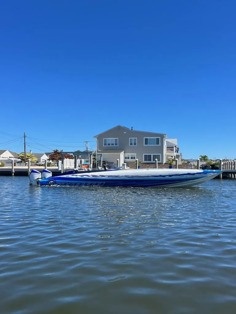 Slide: The Image of 2022 Mystic Powerboats C4000 on water near waterfront home, clear blue sky. - 3